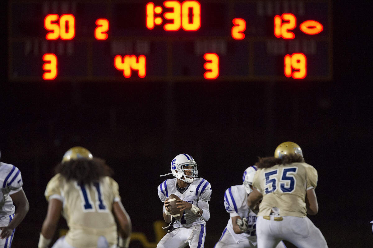 The Dragons' Josiah Johnson drops back to pass during a game between the Sacramento High School Dragons and the Burbank High School Titans at Burbank High School in Sacramento on Friday, Sept. 28, 2012.